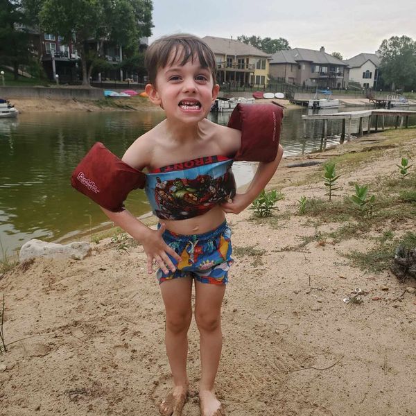 Kid on the beach in floaties