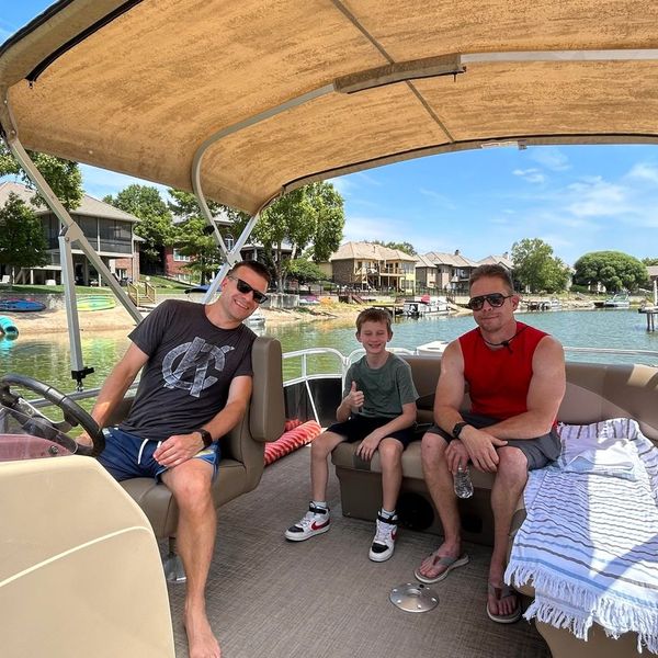 Three on the pontoon boat with lake in background