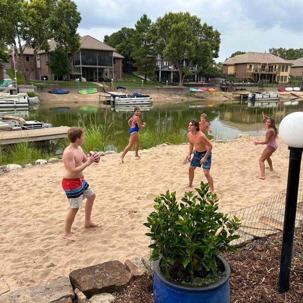 Kids playing football on the lake beach