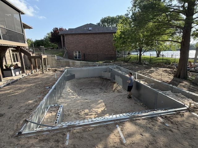 The new pool shell from above, with the lake visible behind it