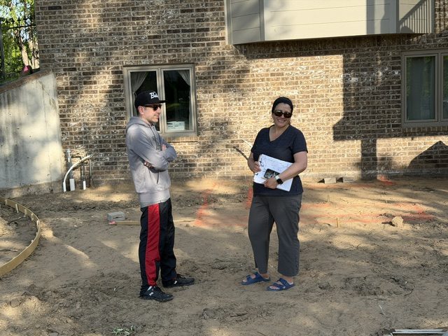 Melanie on site with a clipboard, getting input from Johnny the neighbor