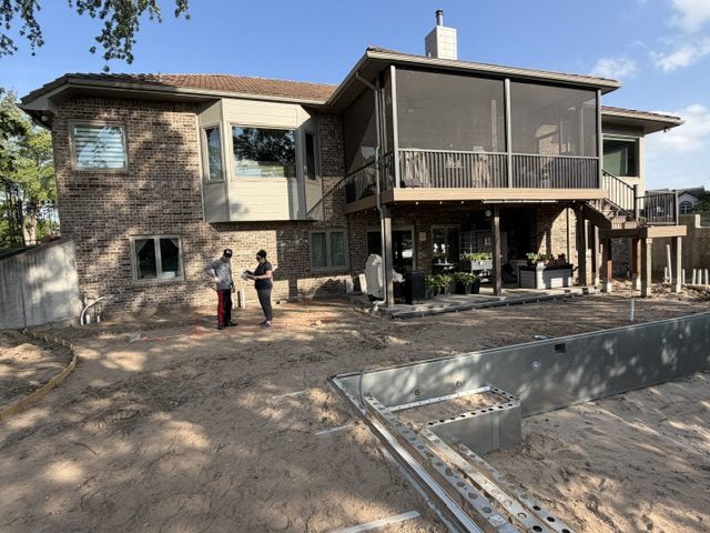 Back of Kevin and Melanie's house showing the screened porch and patio area under construction